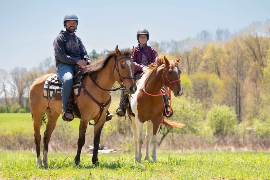 A man and woman riding horses together